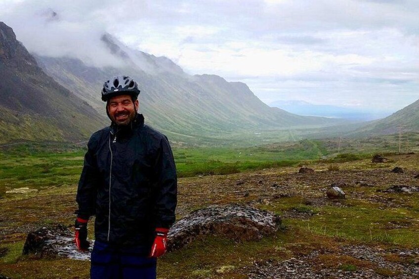 Une personne se tient debout dans un champ herbeux, avec des montagnes en arrière-plan. 5