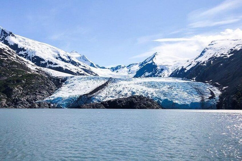 A glacier with snow-covered mountains in the background. 1
