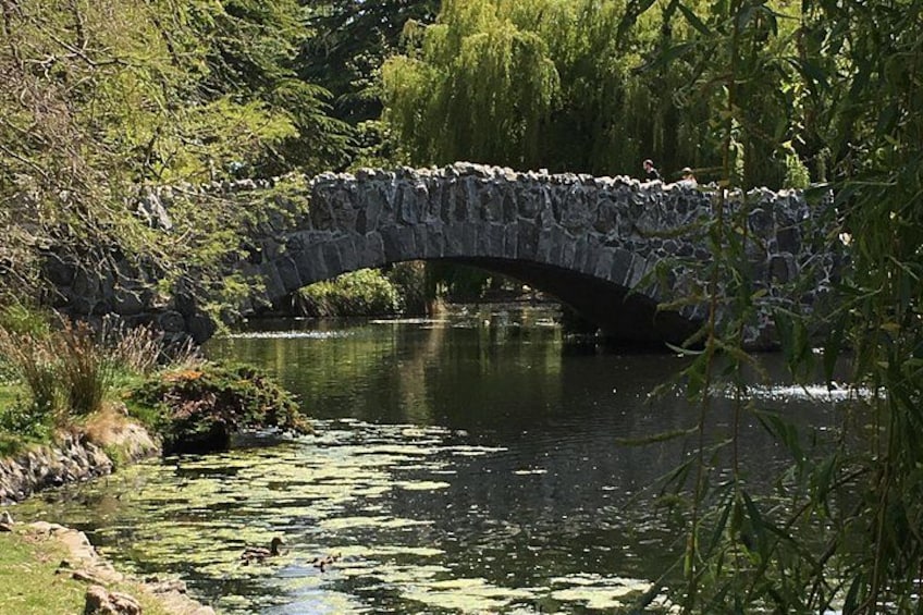 Un ponte di pietra che attraversa un fiume, circondato da vegetazione e alberi. 2