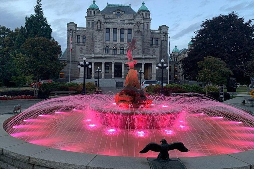 Una fontana con una statua al centro, circondata da un bacino d'acqua circolare. Sullo sfondo, un grande edificio con una cupola e numerose finestre. 4