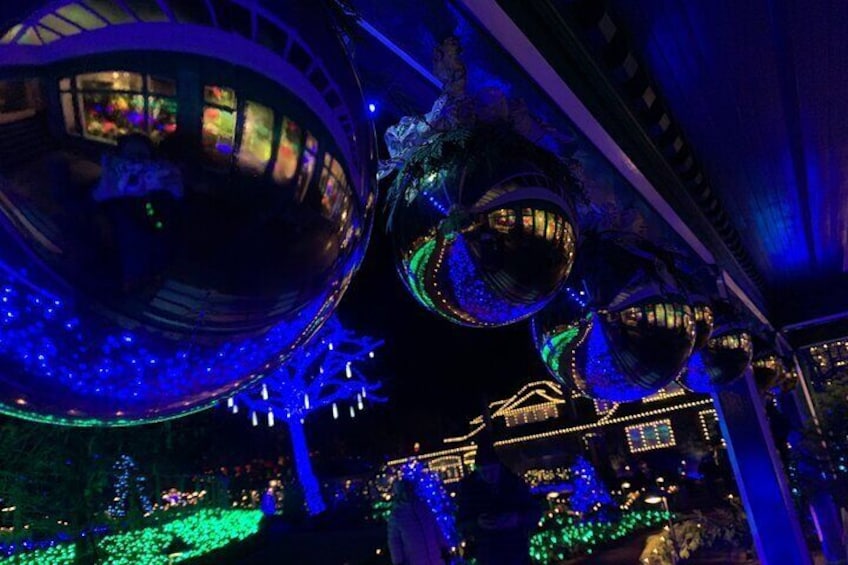 Un amplio espacio interior con estructuras esféricas y árboles iluminados. 4