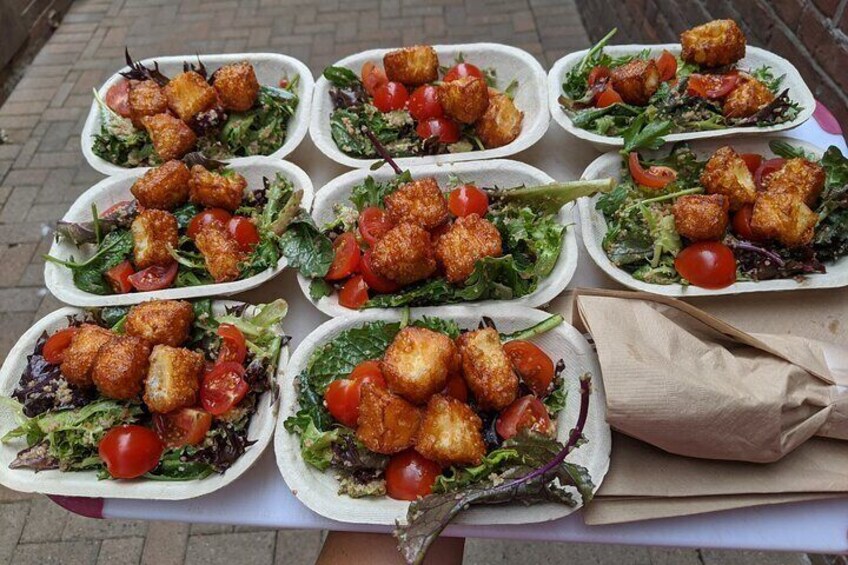 A table with multiple salad bowls containing croutons and greens. 1
