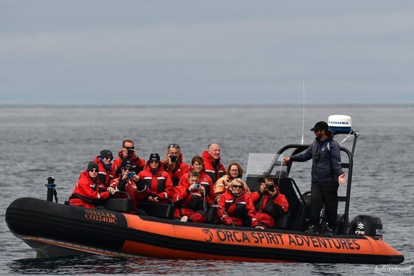 Un grupo de personas en un barco con la inscripción 'ORCA SPIRIT ADVENTURES'. 1