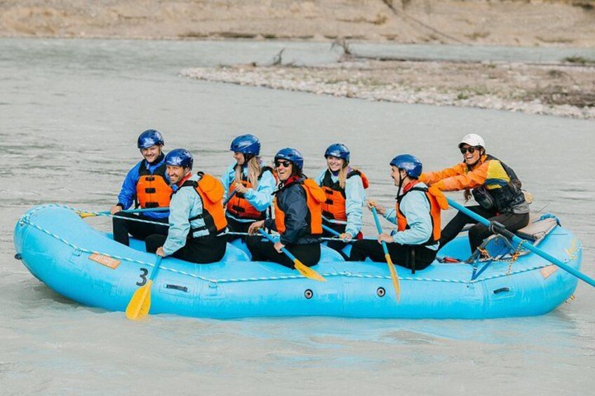 A group of people in a blue inflatable raft on a river. 3