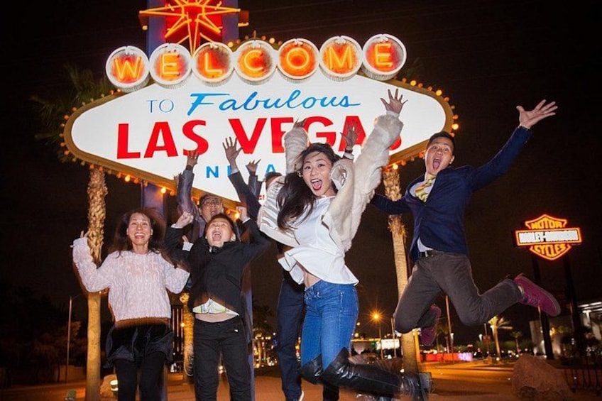 En gruppe mennesker fejrer foran Las Vegas-skiltet. 4
