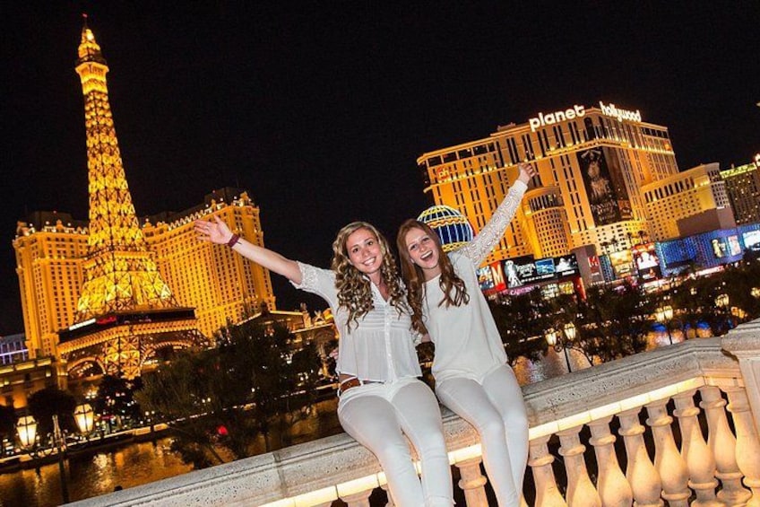 To personer sidder på en balkon med Eiffeltårnet og Planet Hollywood i baggrunden. 5