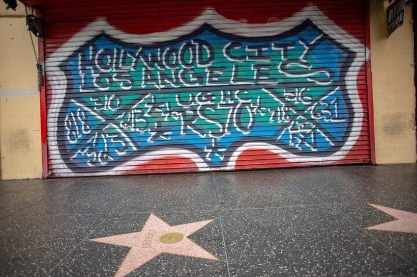 Street art frames a part of the Hollywood Walk of Fame which includes over 2,600 five-pointed stars and publicly celebrates the achievements of America’s entertainment industry.