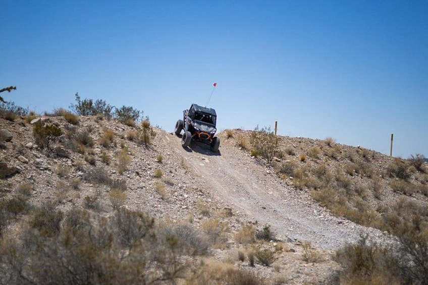 A vehicle on a dirt road in a dry, hilly landscape. 5