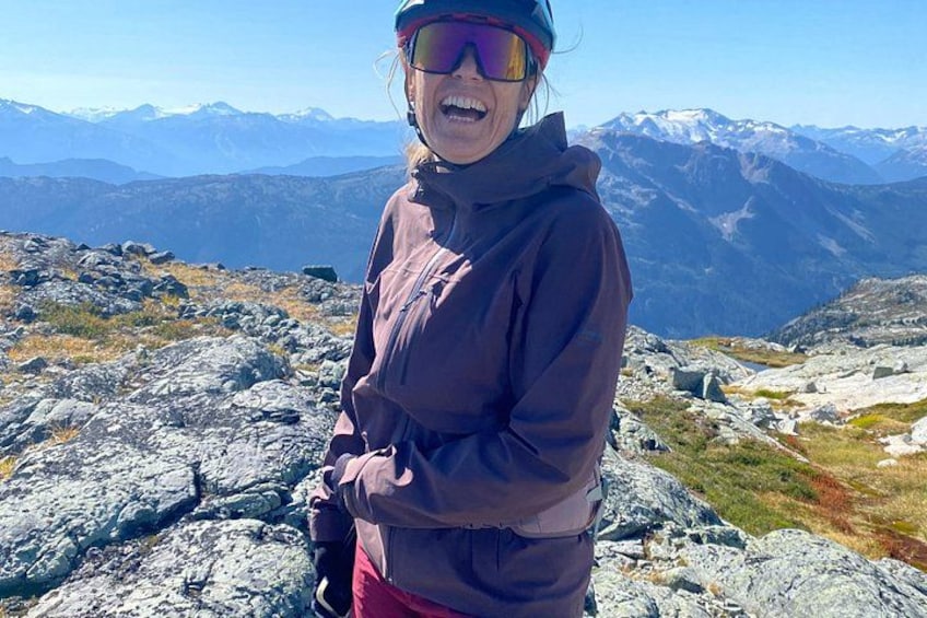 Eine Person steht auf felsigem Gelände, im Hintergrund eine Berglandschaft. 3