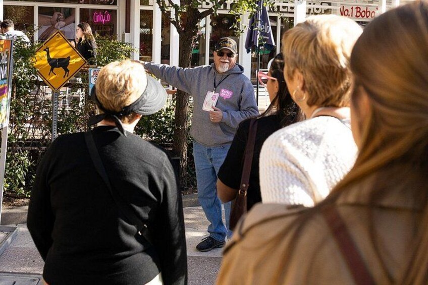 A street scene with pedestrians, a yellow deer crossing sign, and a person gesturing. 3