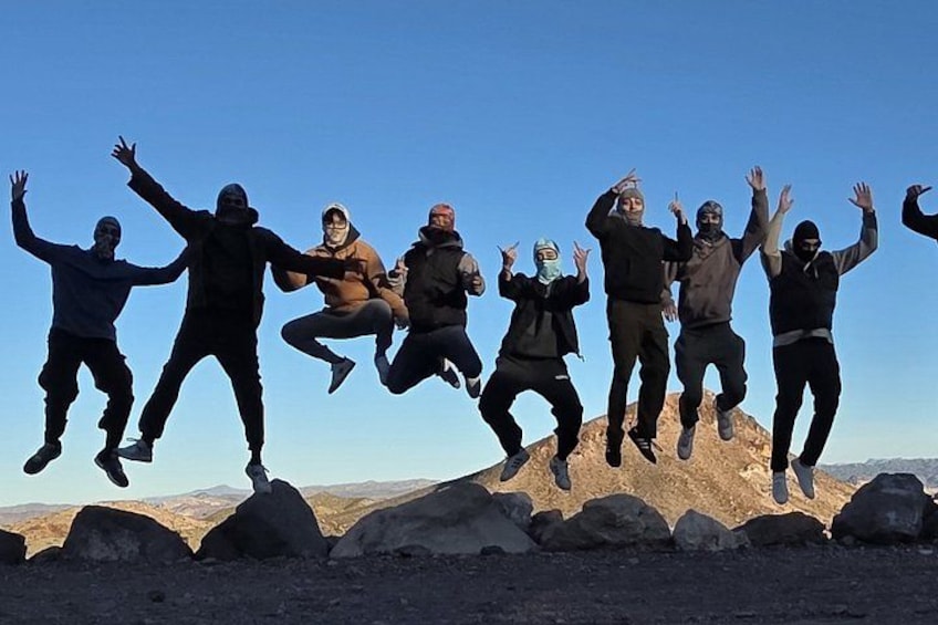 A group of people jumping in mid-air against a clear sky. 4