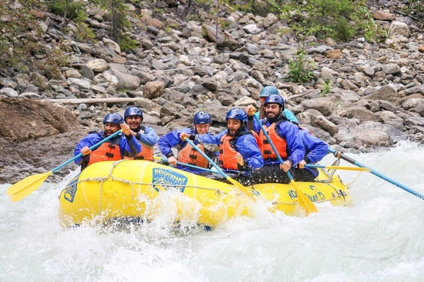 A group of people in a yellow raft navigating a river. 2