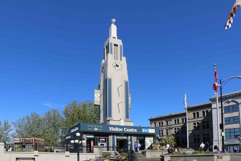 A tall building with a clock, a visitor center, and a flag. 4