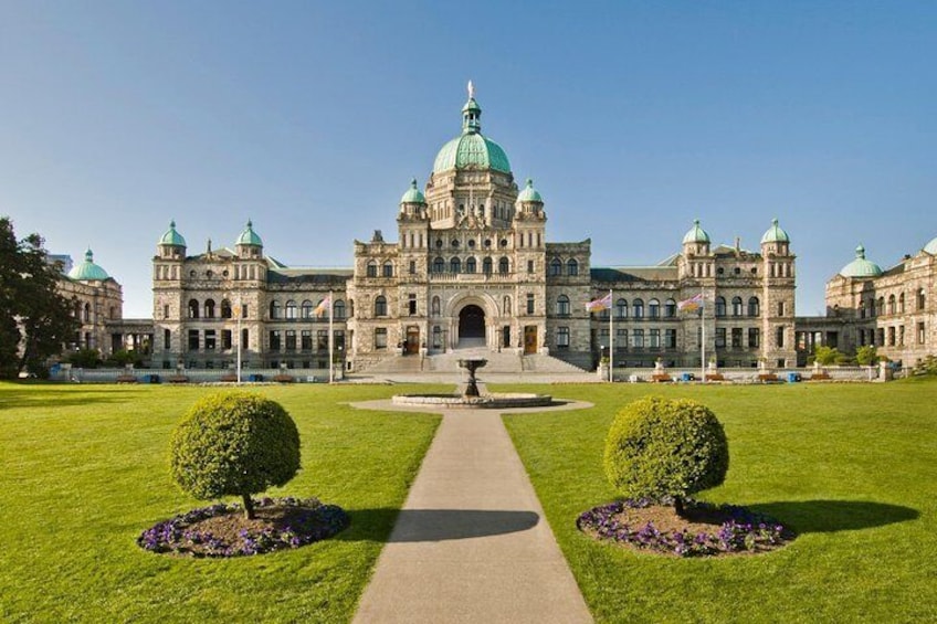 A large, historic building with a central dome and multiple smaller domes, surrounded by well-maintained lawns and flower beds. 2