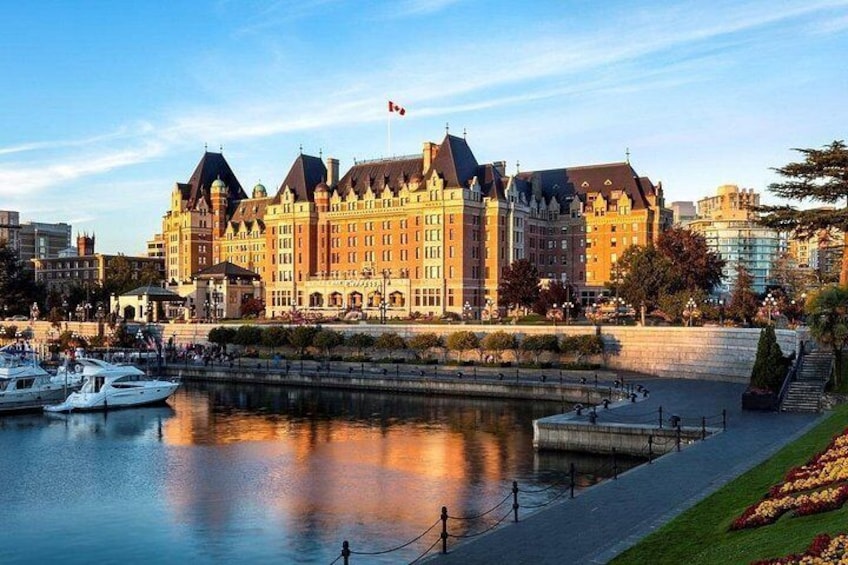 A large historic building with a waterfront, boats docked in the foreground, and a clear sky. 4