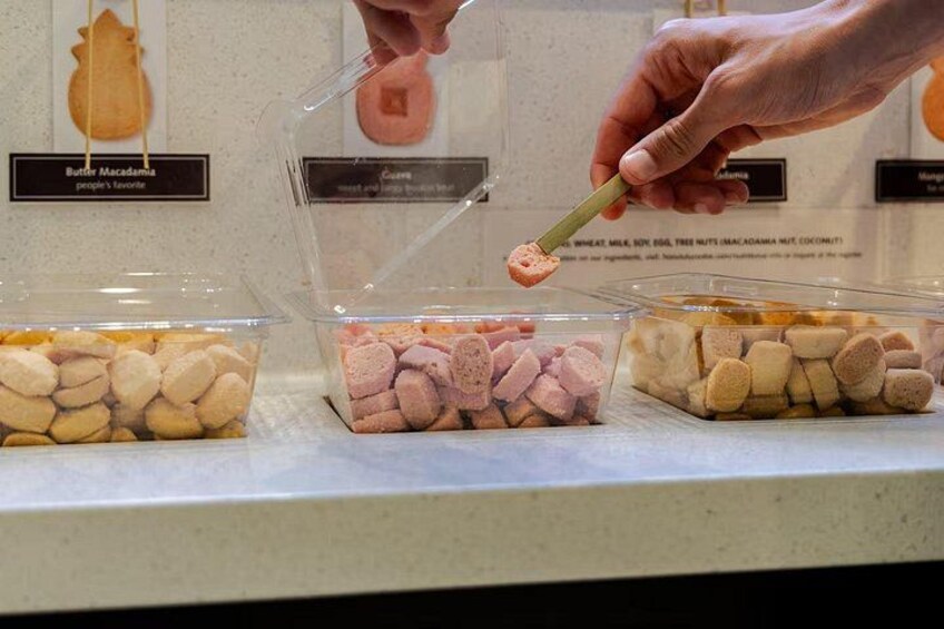A person selecting a macadamia nut from a container. 4