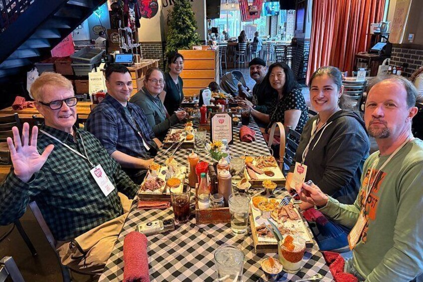 A group of people seated at a table with food and drinks. 4