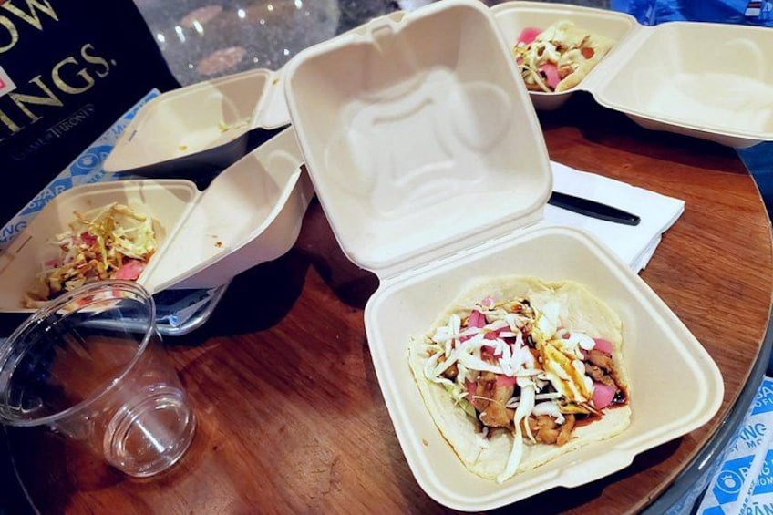 A table with food containers, one open with a taco inside. 3