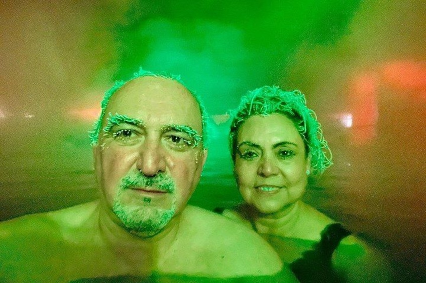 Two people in a green-lit environment, possibly a sauna or steam room. 4