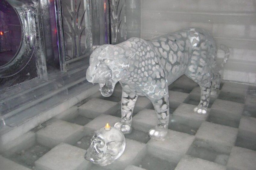 A glass sculpture of a leopard with a skull at its feet. 2