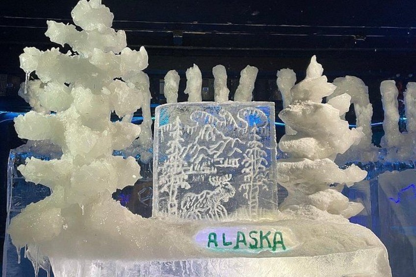 An ice sculpture with a sign labeled 'Alaska' and a mountain landscape design. 4