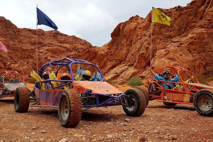 Véhicules tout-terrain dans un environnement désertique, sur un terrain rocheux, avec des drapeaux. 1