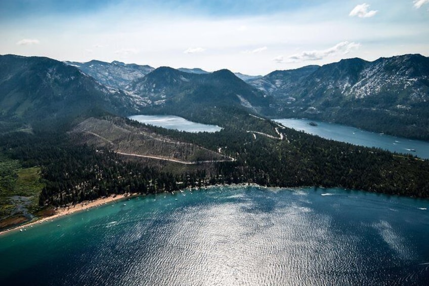 A coastal landscape with a lake surrounded by mountains and a forested area. 3