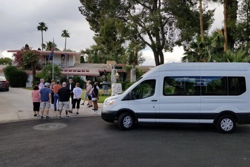 Una camioneta blanca estacionada en una calle, con un grupo de personas cerca. 4