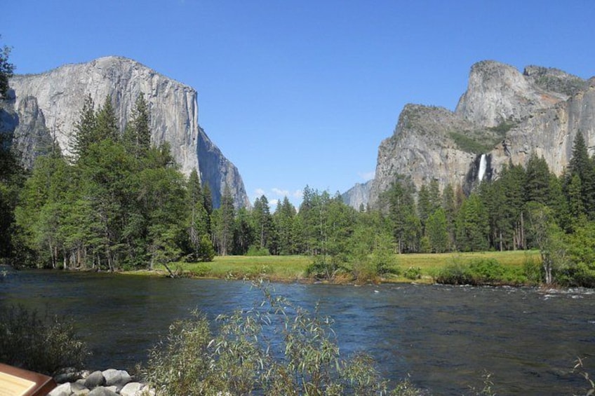 Une rivière avec une cascade, entourée d’arbres et de montagnes. 5