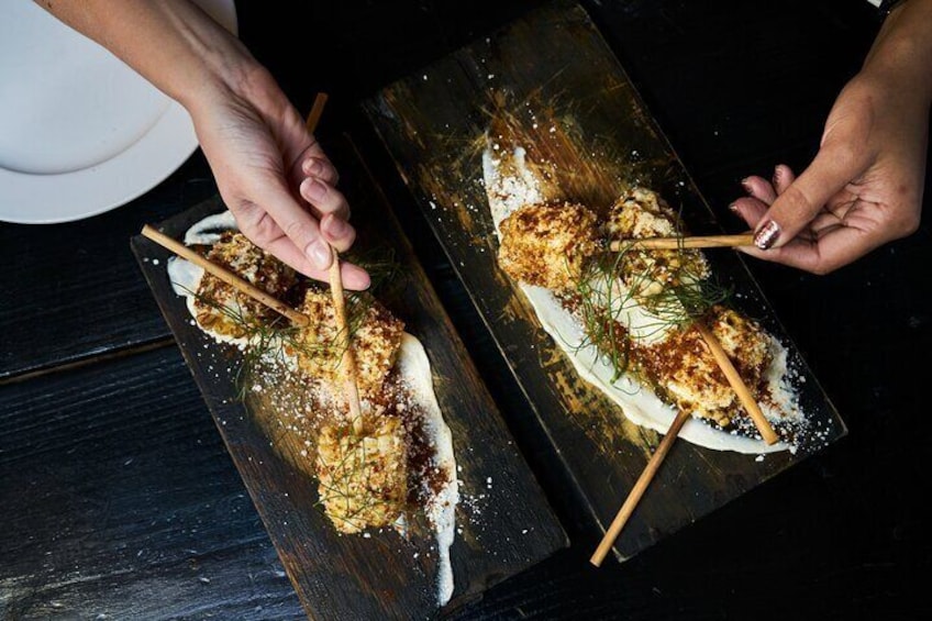 Two skewers of food on a dark wooden board. 5