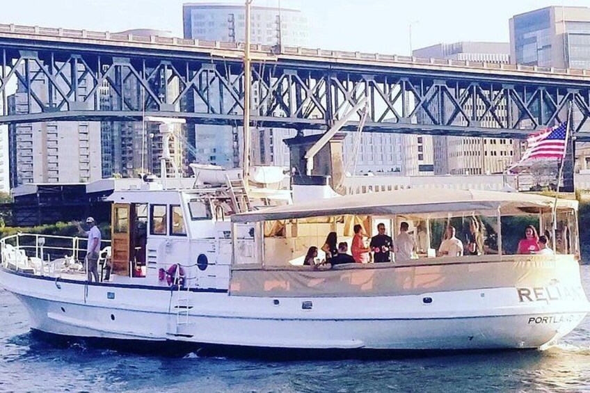 Un bote blanco con la palabra 'RENT' escrita, amarrado cerca de un puente con una bandera estadounidense. 3