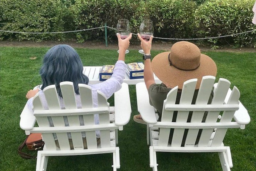 Dos personas sentadas en sillas Adirondack blancas, enfrentadas, con una mesa entre ellas. 3