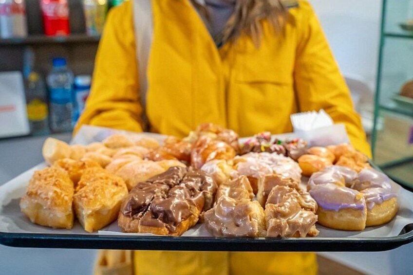Ett fat med ett urval av bakverk, inklusive croissanter, wienerbröd och munkar. 2