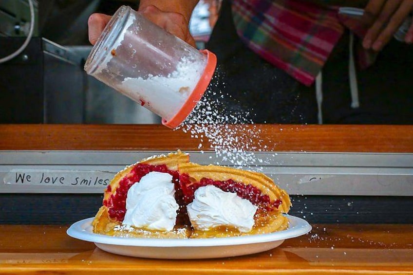 Un pastel con crema batida en un plato, con azúcar glas espolvoreada encima. 2