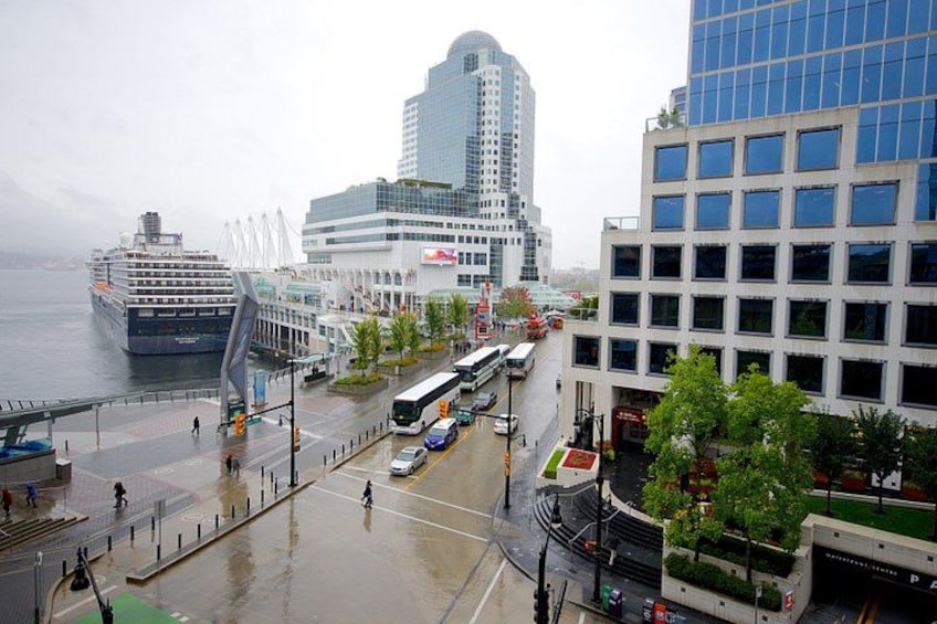 A waterfront cityscape with modern buildings, a cruise ship, and a bus terminal. 2