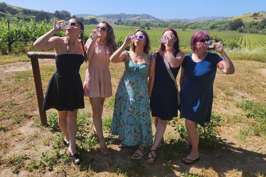 A group of people standing in a vineyard. 4