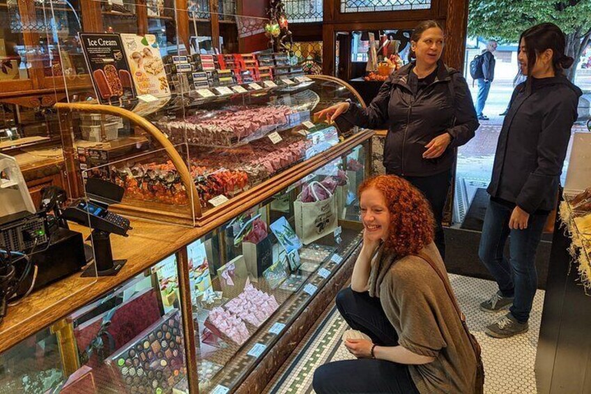 Un expositor de panadería con diversos productos horneados y una caja registradora. 3