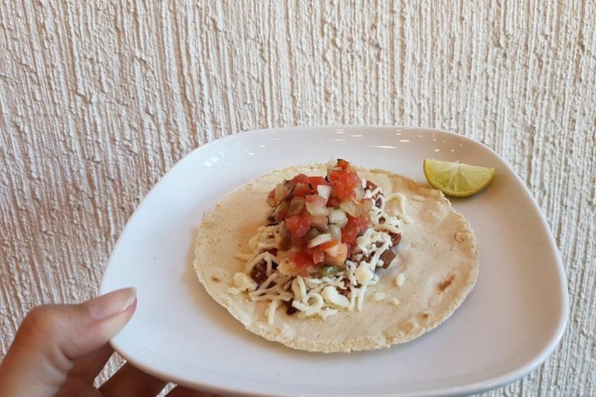 A plate with a taco and a lime wedge. 3