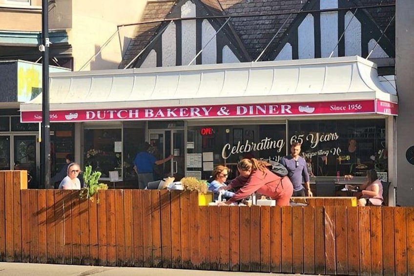 A Dutch bakery and diner celebrating 65 years, with people dining outside. 2