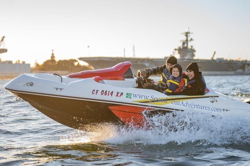 A speedboat with three people on board, moving through water. 1