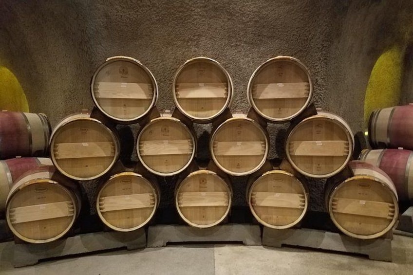 A collection of wooden barrels arranged in a pyramid shape. 3