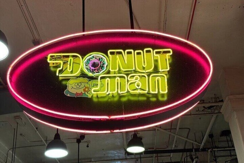 A neon donut sign with cartoon characters. 5