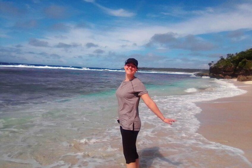 A person standing on a beach with waves in the background. 2