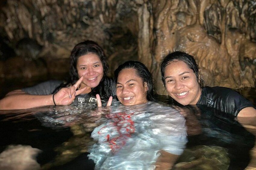 Three people in a hot spring with a cave-like background. 4