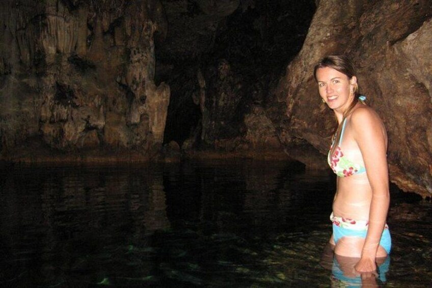 En person som står i en grotta med vatten i botten. 1