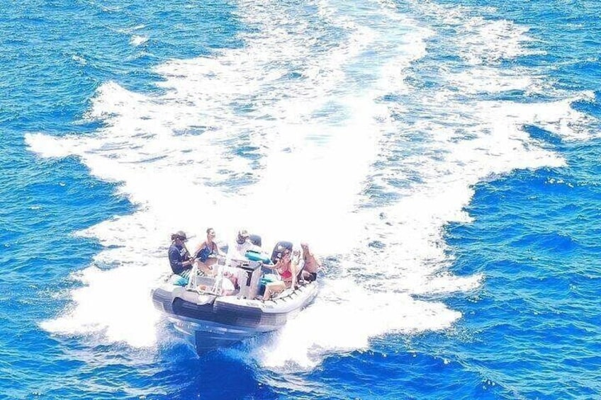 A boat with people on a blue body of water. 3