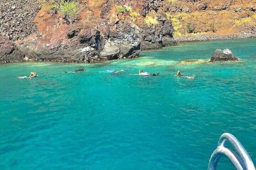 Clear turquoise water, a rocky shoreline, and a boat. 2