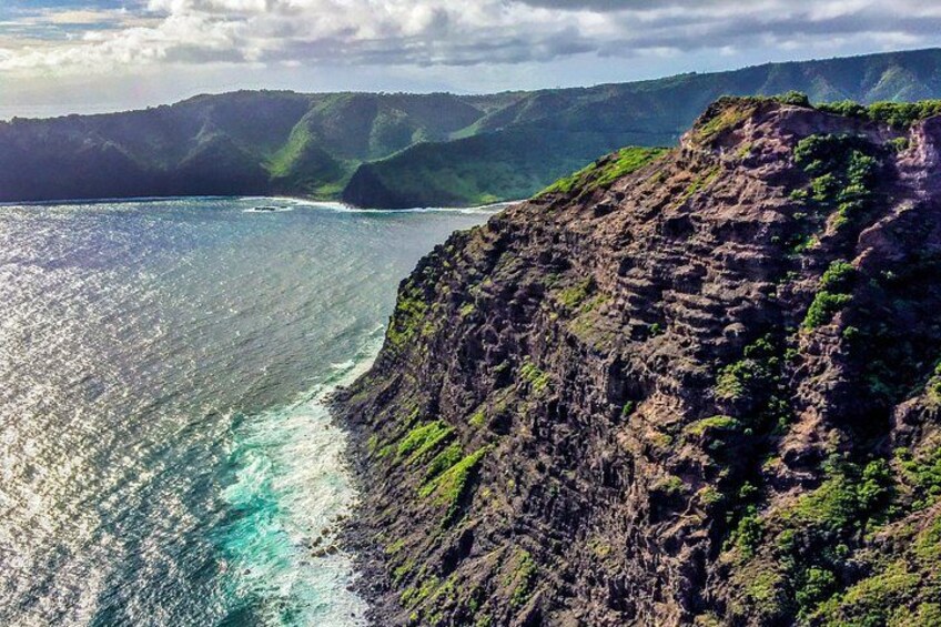 A coastal cliff with a rugged coastline and a clear view of the ocean. 2