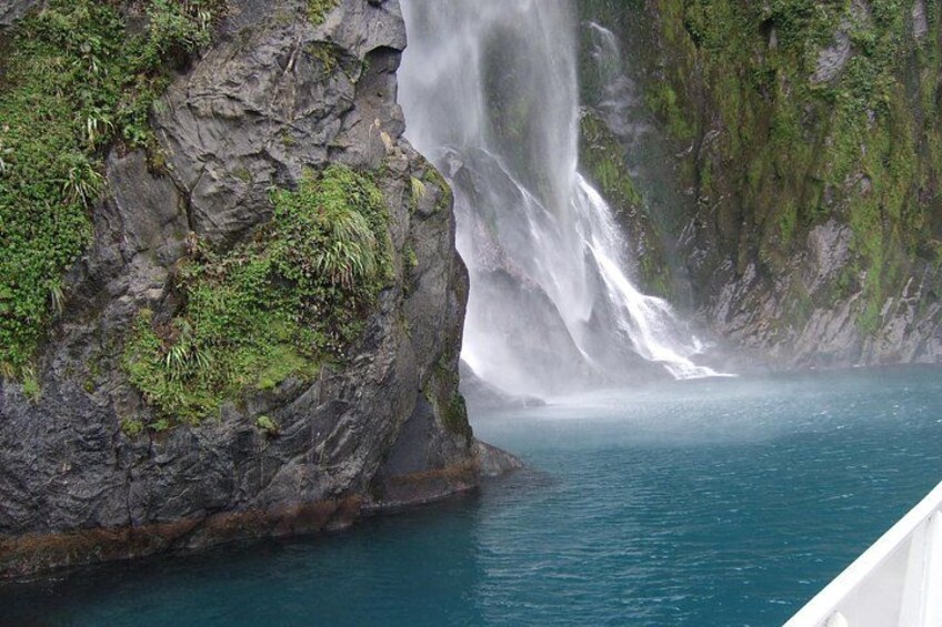 A waterfall cascading into a body of water surrounded by rocky cliffs. 3
