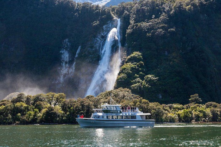 A boat on a river with a waterfall in the background. 2